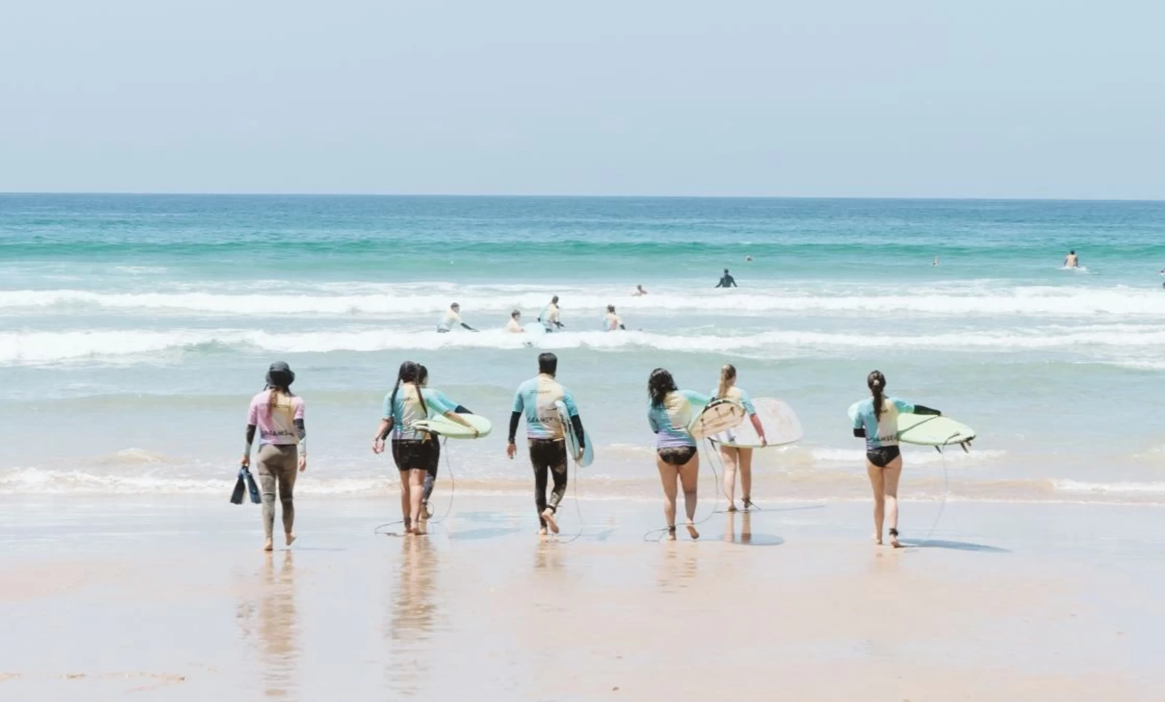 Anfänger Gruppe im Surfcamp auf dem Weg in den Ozean