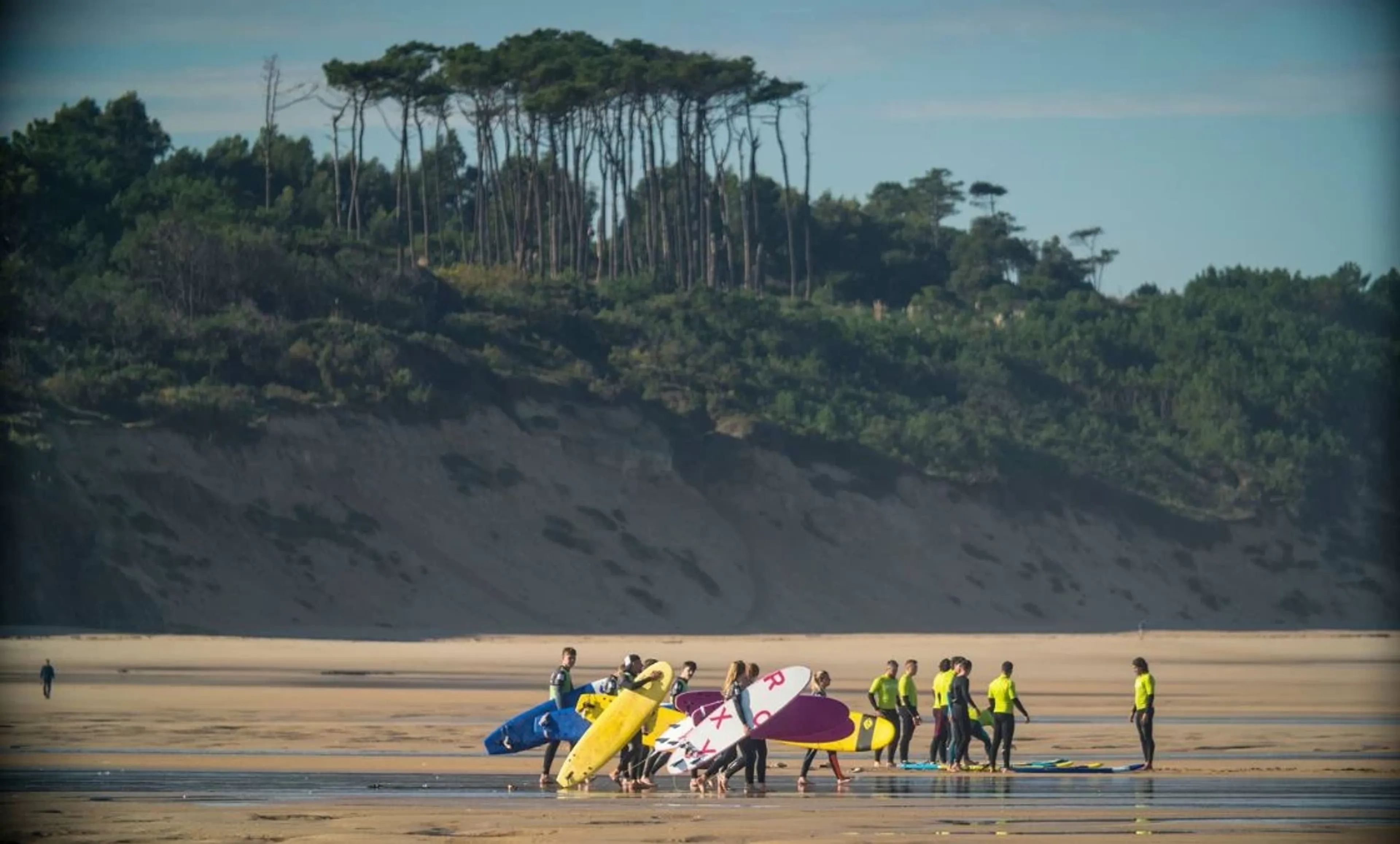 Surfcamp Gruppe am Strand auf mit den letzten Instruktionen bevor es ins Wasser geht