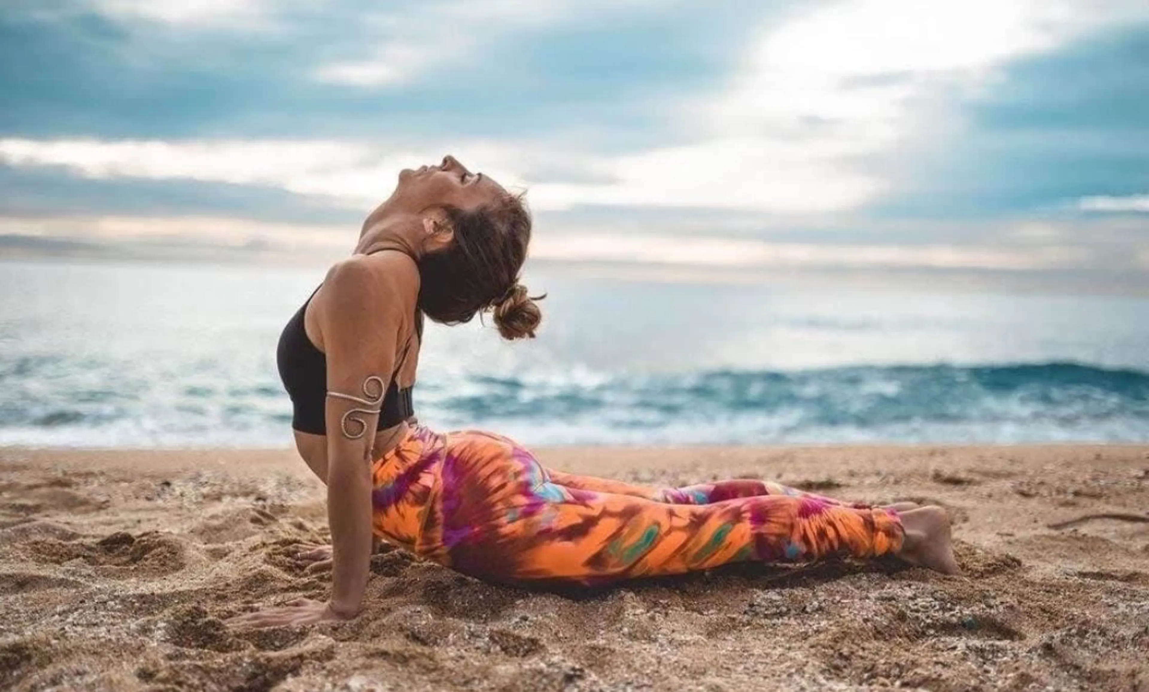 Frau in Kobra Yoga Pose beim Yoga Retreat am Meer