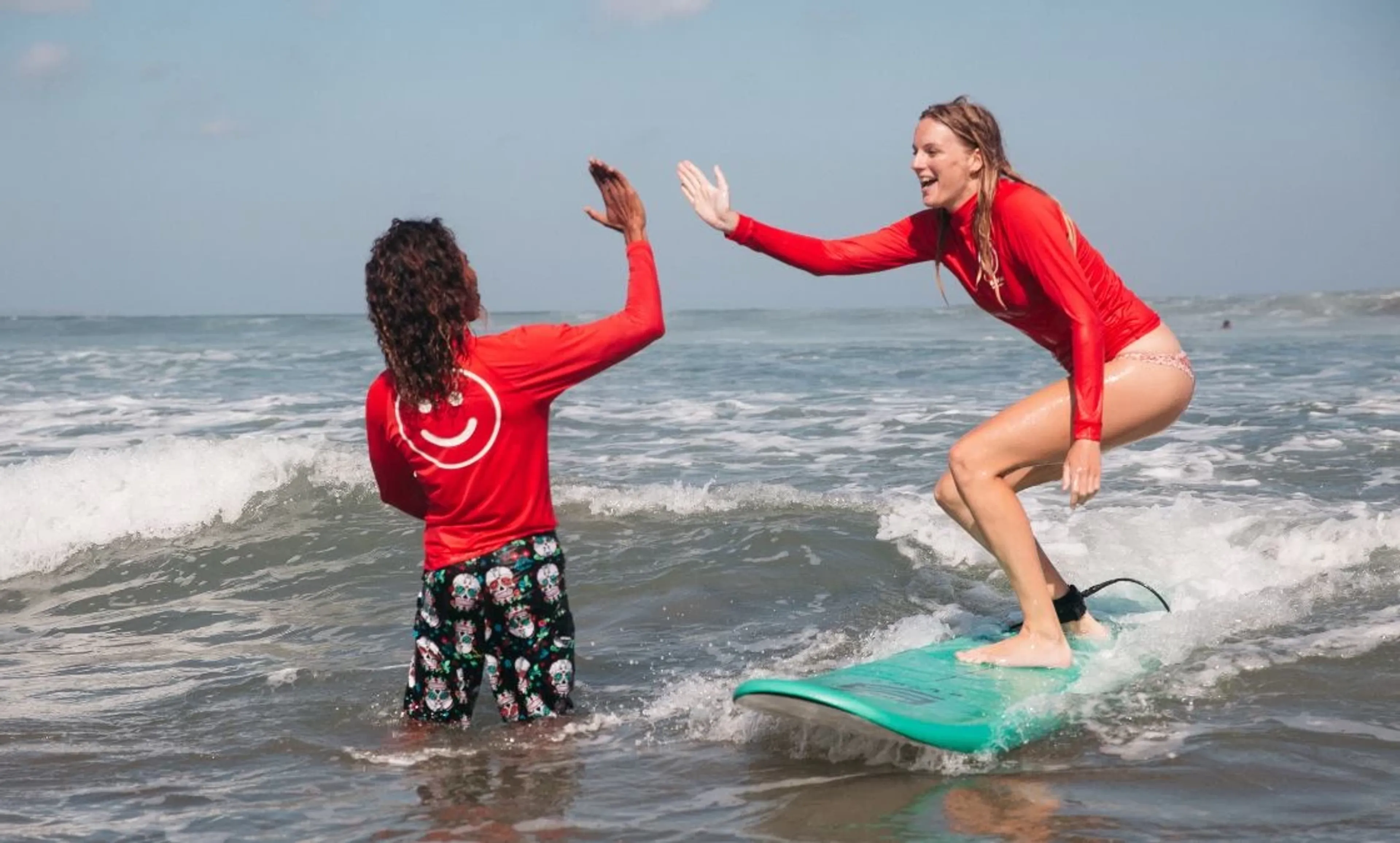 Surfen lernen mit Surflehrer in den Wellen im Surfcamp