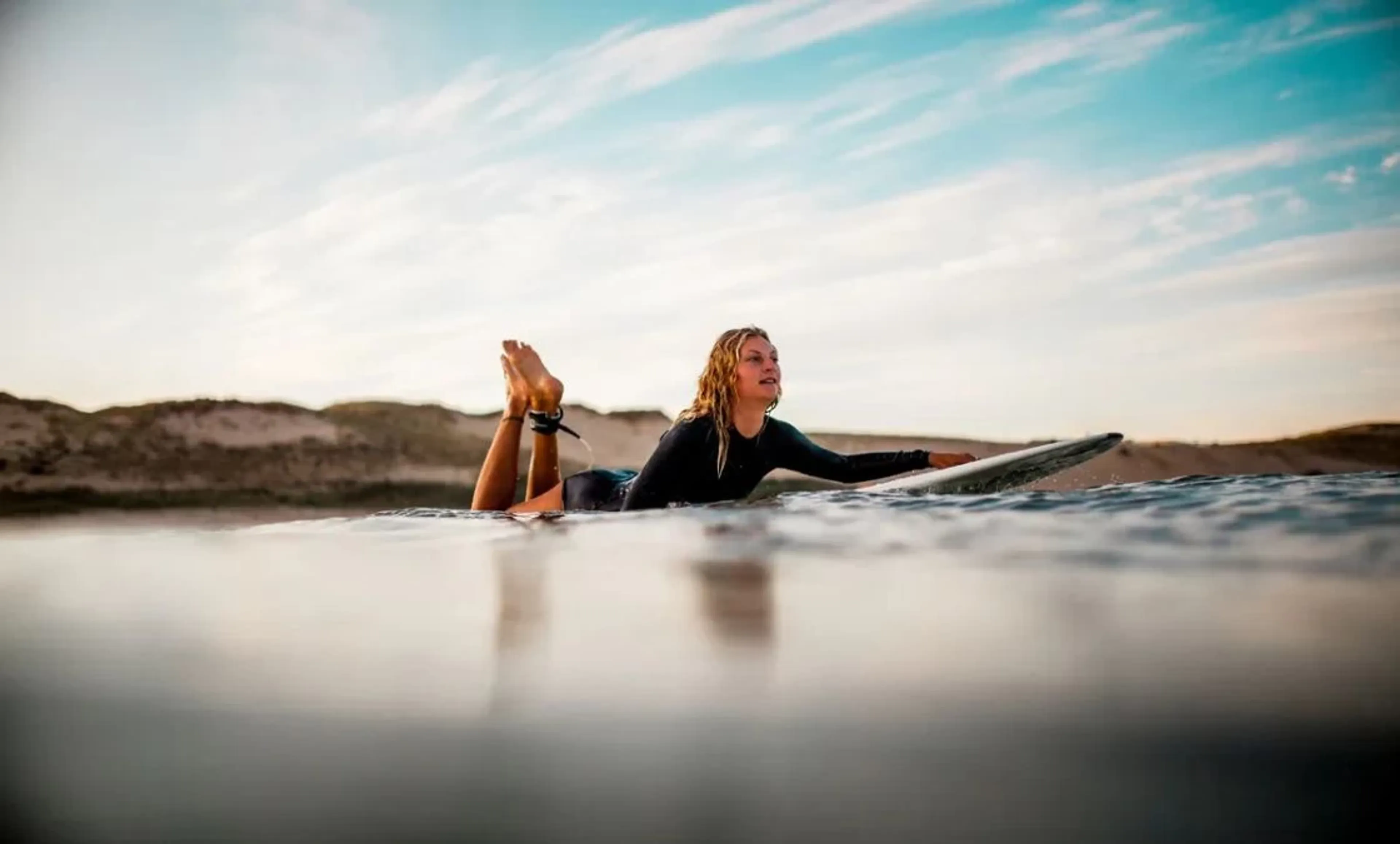 Surf-Anfängerin paddelt ins Line-Up