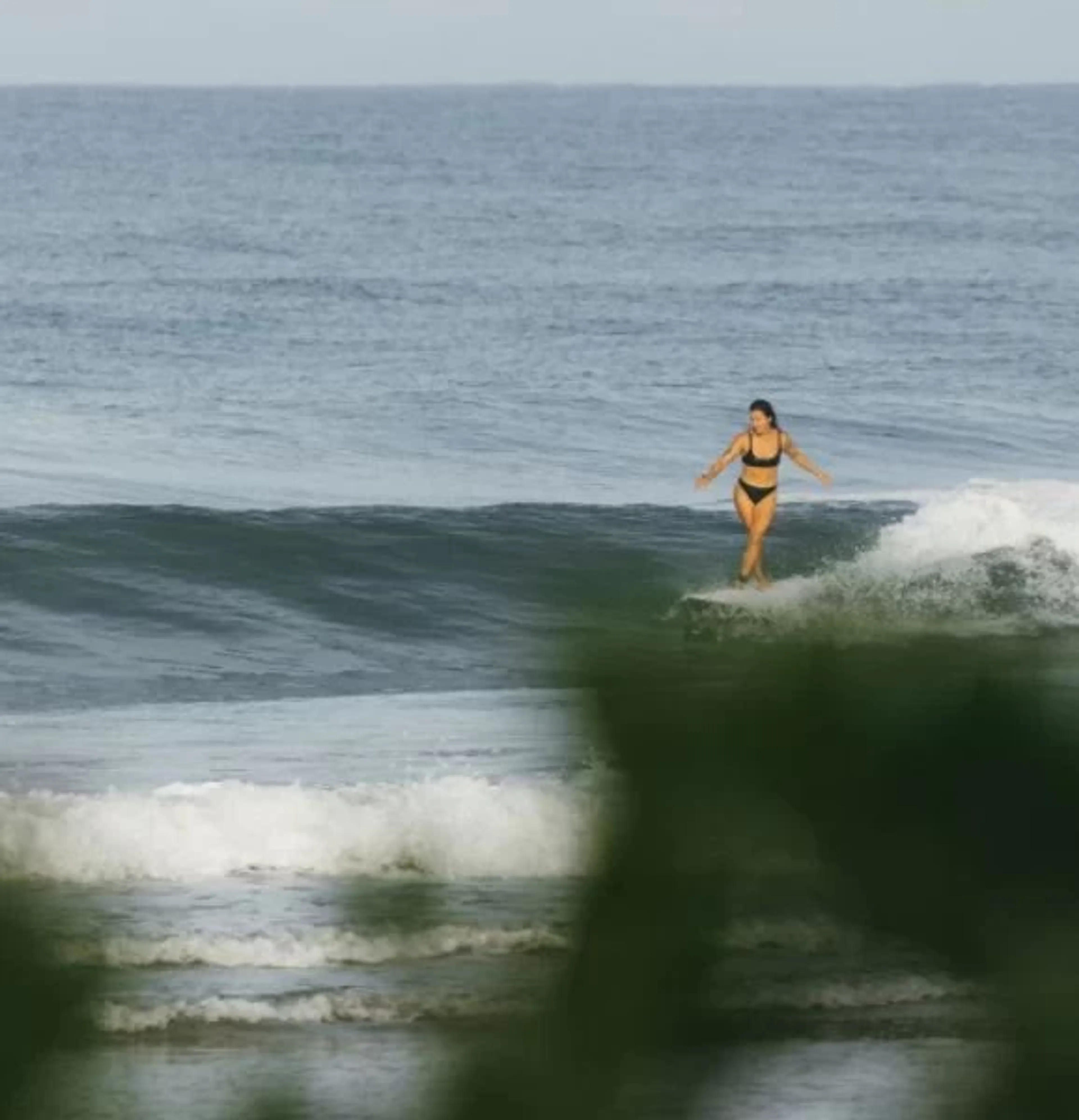 Frau beim Surfen im Yoga & Surf Camp in Portugal