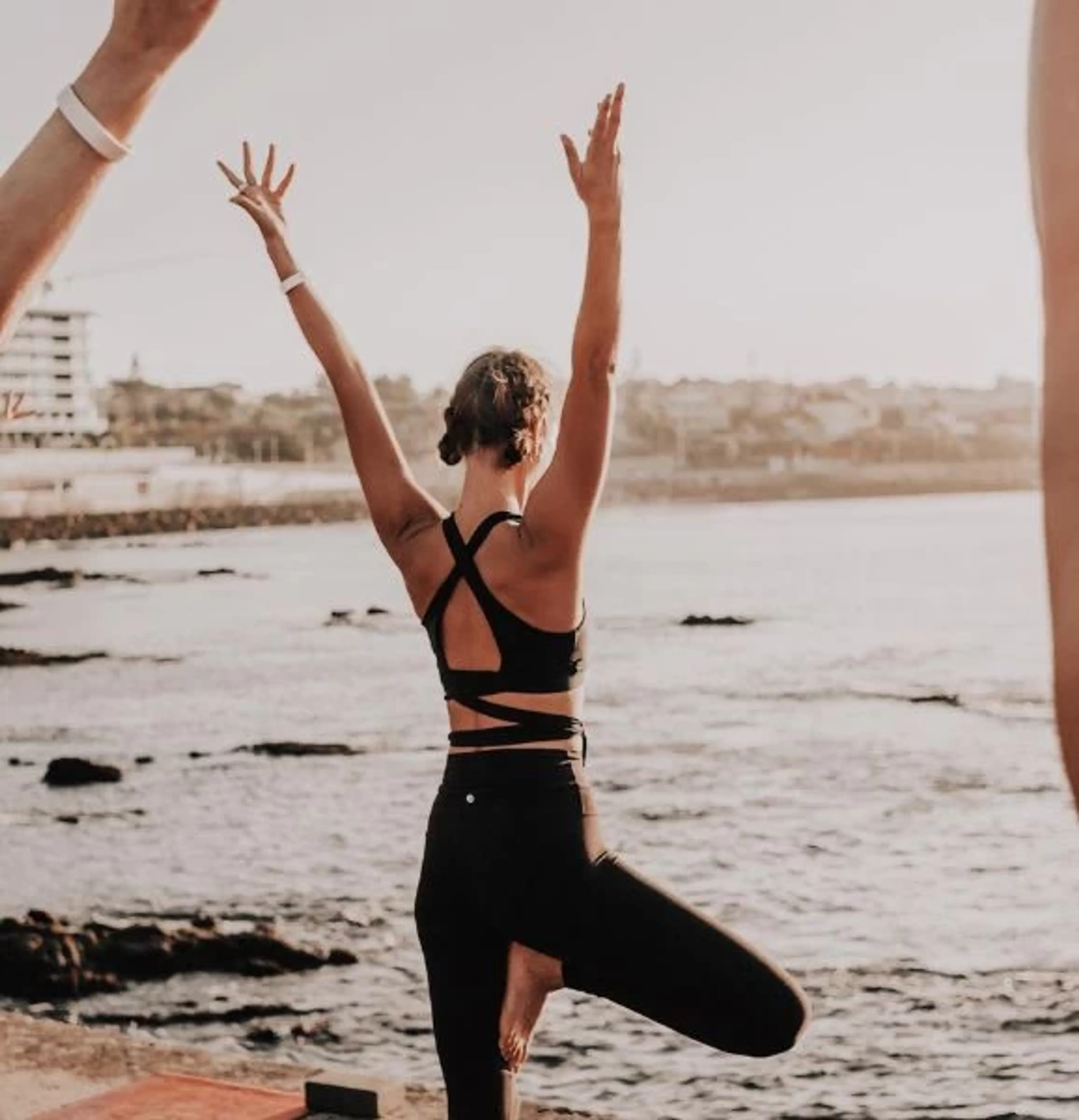 Frau beim Yoga am Strand im Yoga & Surf Retreat in Portugal