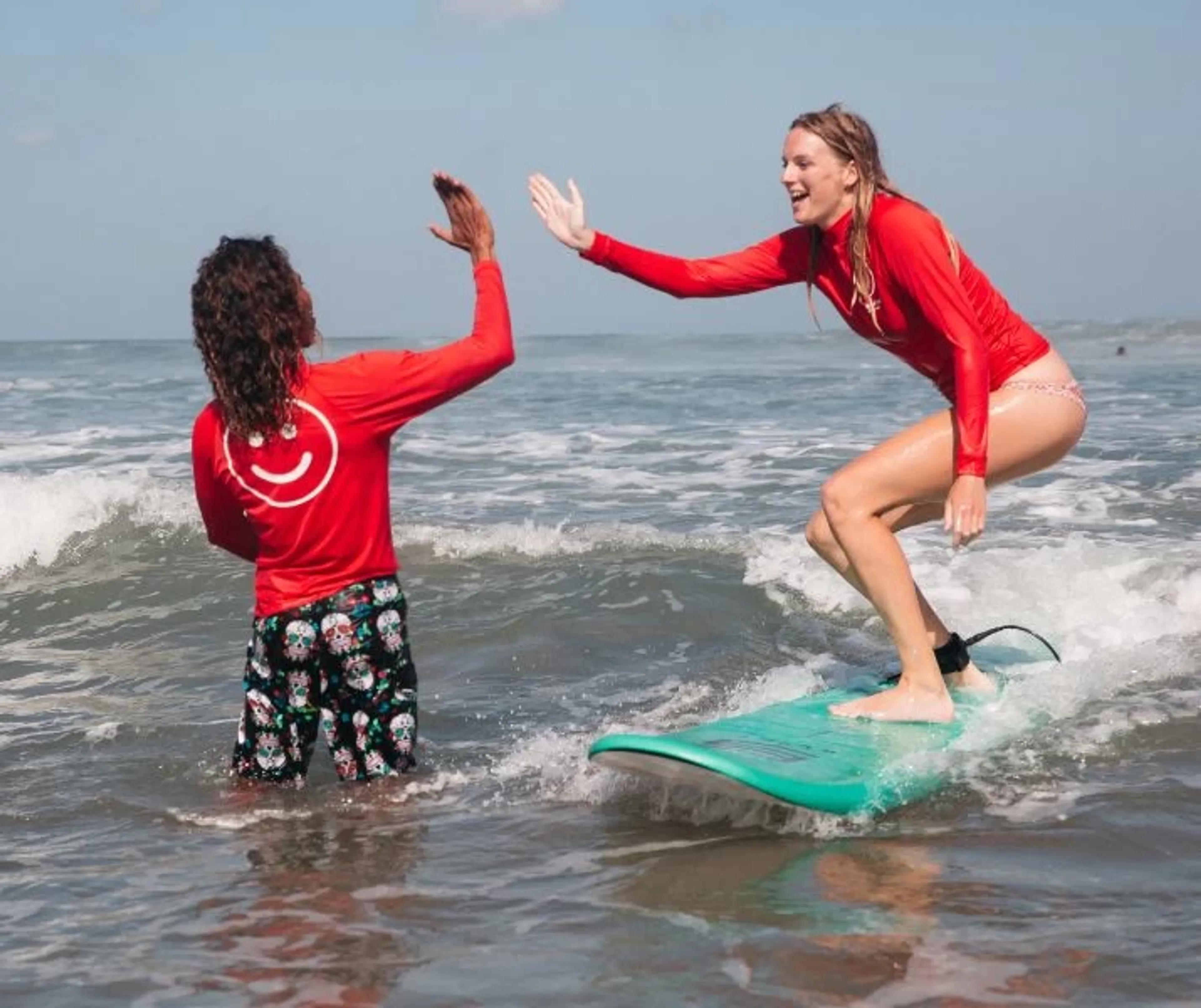 Surfen lernen mit Surflehrer in den Wellen im Surfcamp