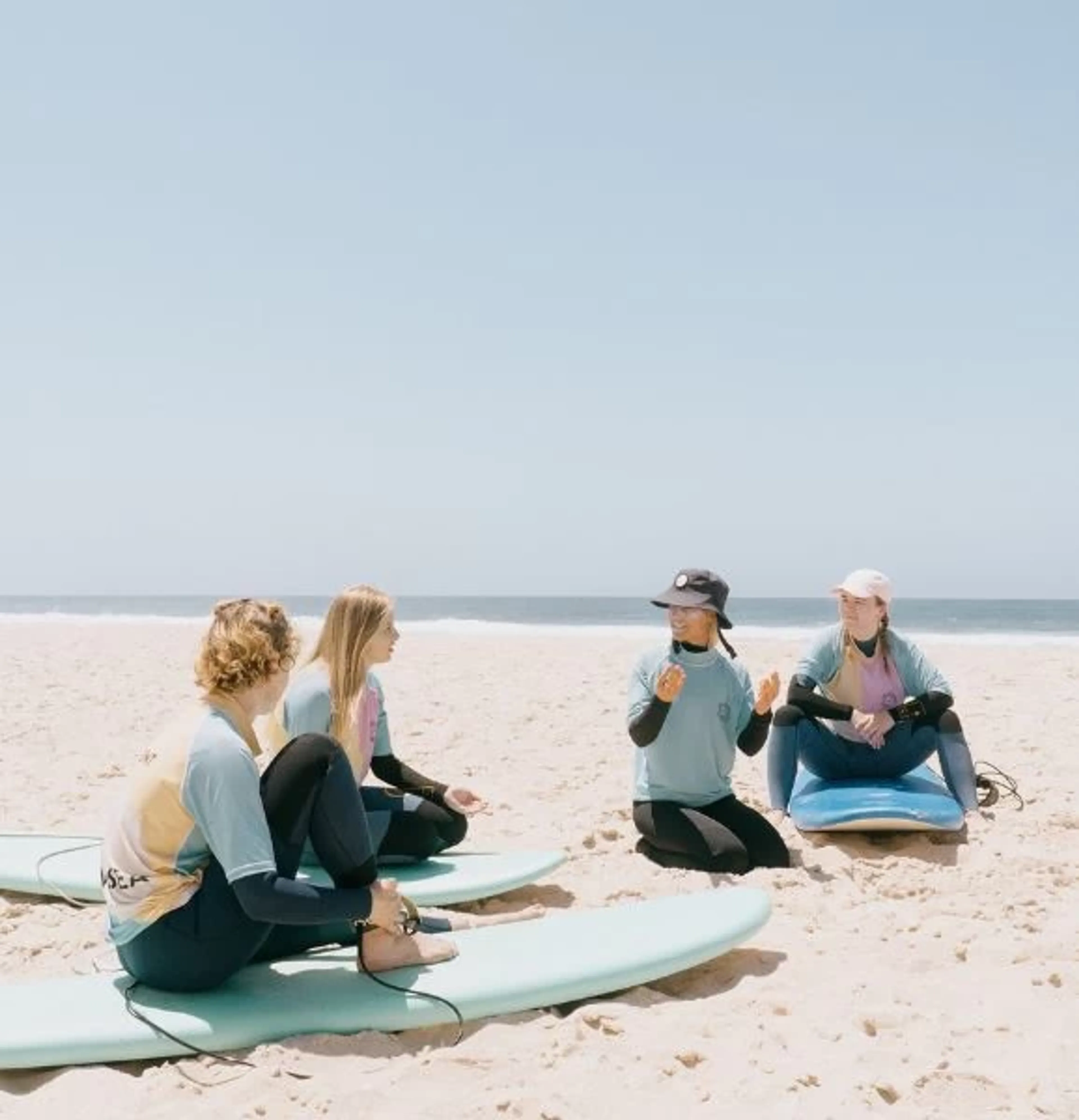 Surflehrerin erklärt Surftheorie am Strand