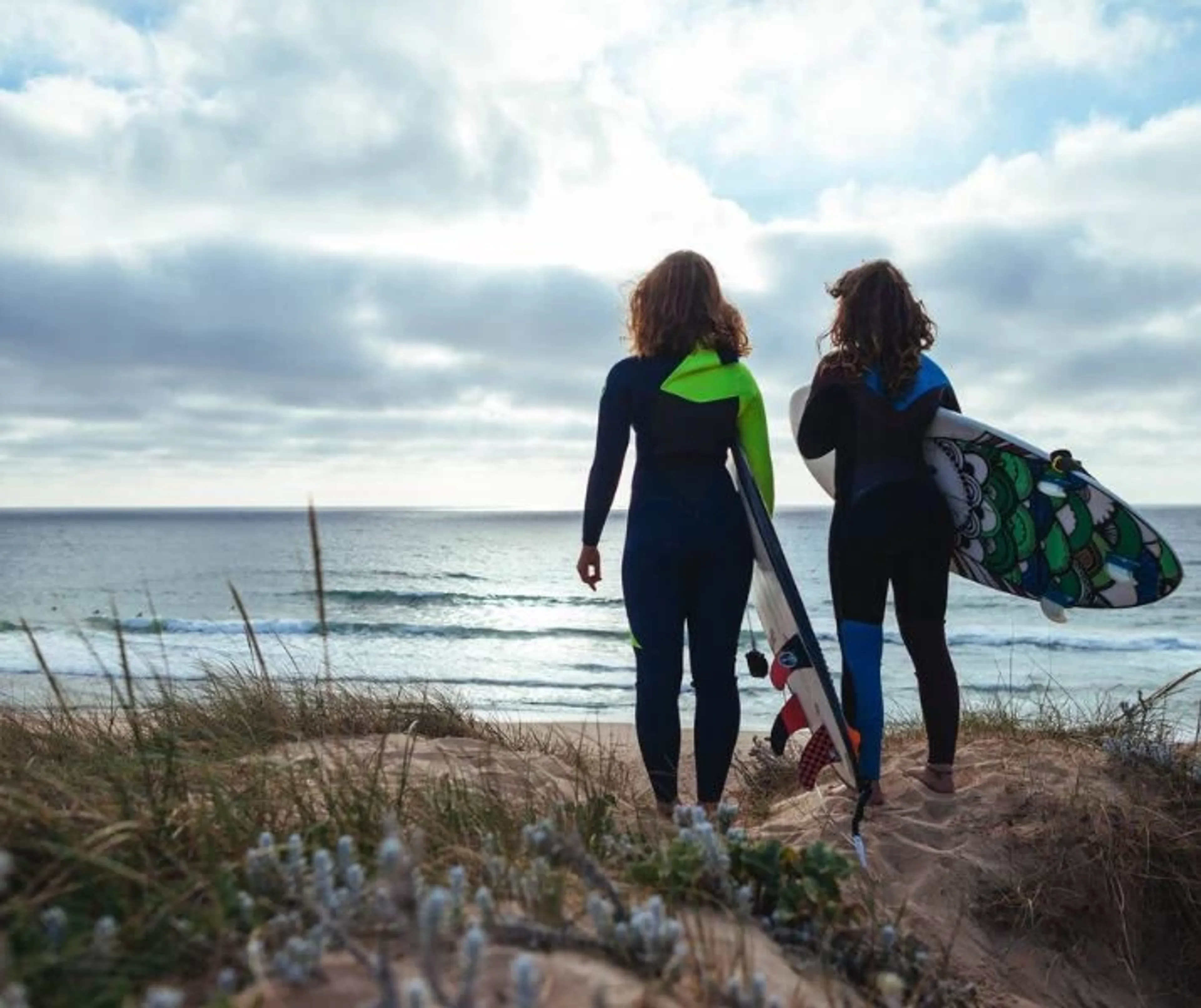 Zwei Surfer in Portugal beobachten die Wellen von der Klippe