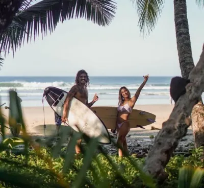 Paar mit Surfboards am Strand auf dem Weg zum Surfen