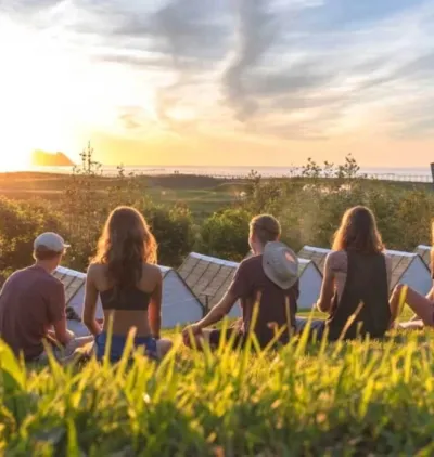 Gruppe schaut den Sonnenuntergang in der Natur im Surfcamp in Zarautz