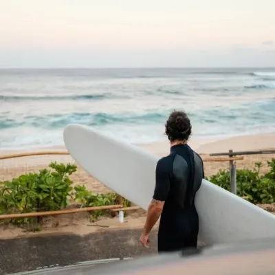 Surfer blickt auf Strand und Wellen von Taghazhout