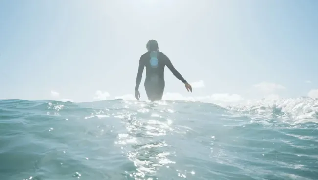 Surferin bei Sonnenaufgang in der Welle