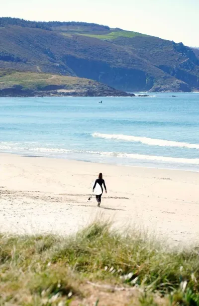 Surferin am einsamen Sandstrand in Galicien