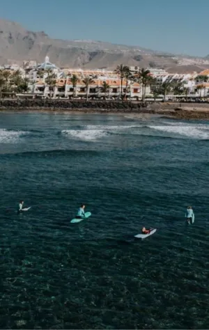Surfcamp Gruppe in den Wellen mit Blick auf den Vulkan auf Teneriffa
