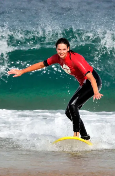 Surf-Anfängerin surft Weißwasser-Welle auf Fuerteventura