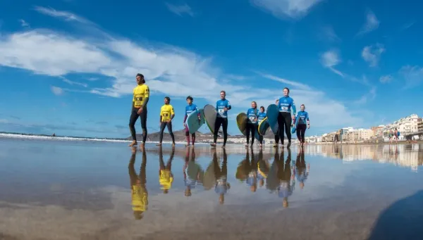 Surfcamp Gruppe mit Surfboards am Strand in Las Palmas de Gran Canaria
