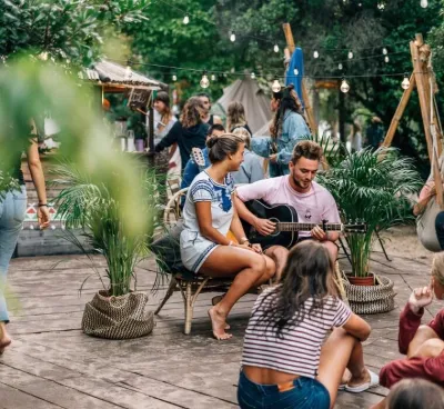 Gruppe beim Gitarre spielen und entspannen im Surfcamp in Frankreich