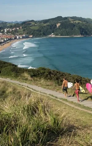 Surfcamp-Gruppe läuft zum Surfen an den Strand in Zarautz im Baskenland