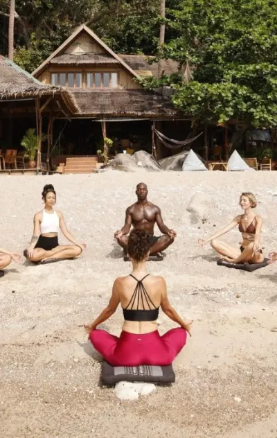 Gruppe beim Yoga am Strand im Retreat in Thailand