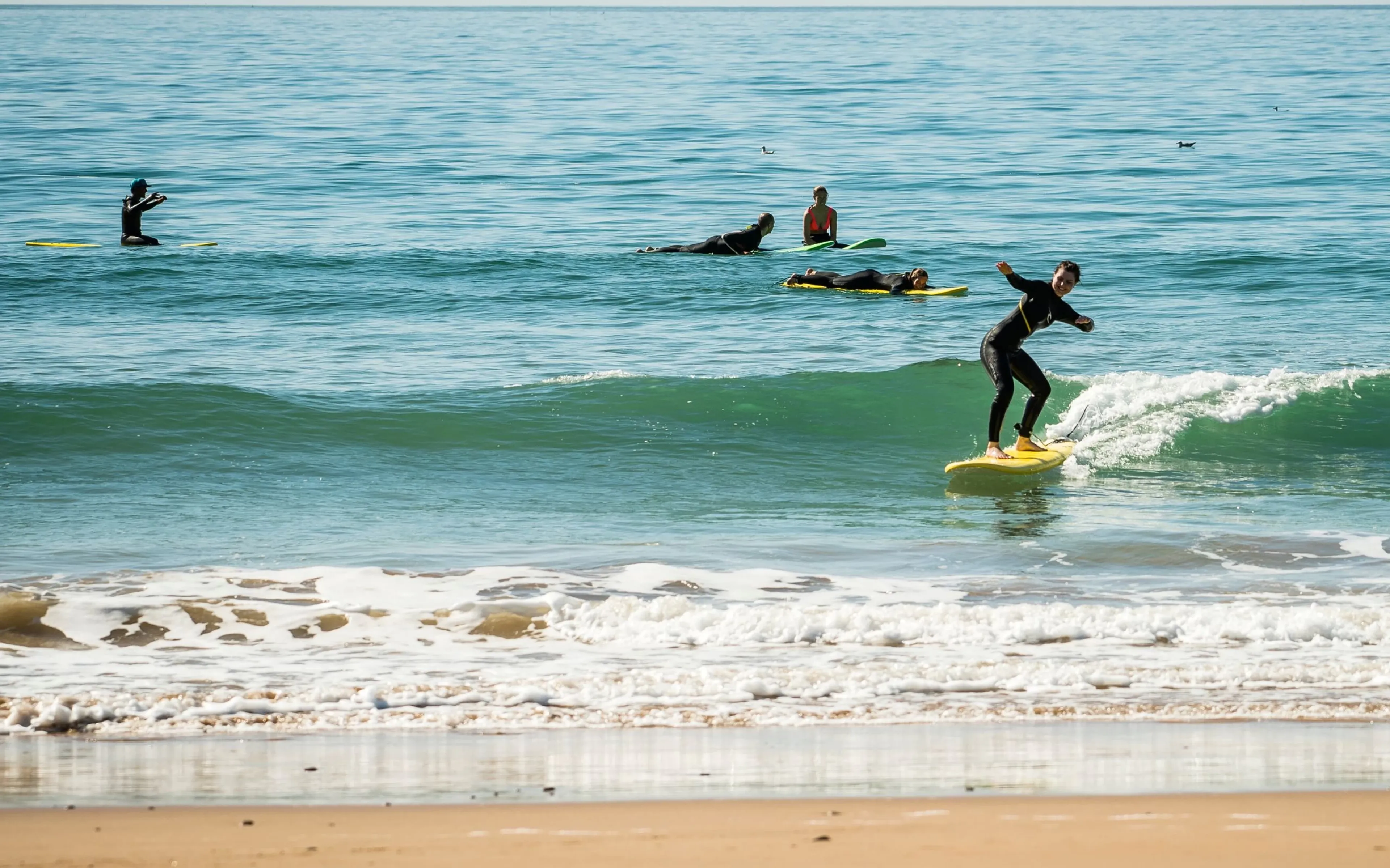 Anfängerin surft Welle im Surfcamp in Marokko