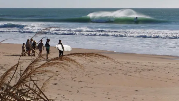 Blick vom Strand in Andalusien auf Surfer in den Wellen