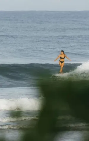 Frau surft cleane Welle im Bikini in Sri Lanka