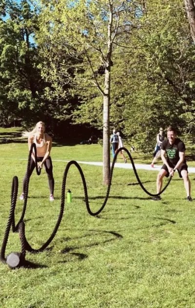 Fitnessgruppe beim Training mit Seilen im Park in Deutschland