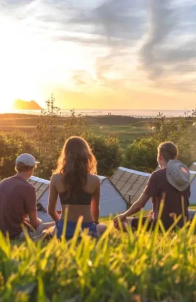 Gruppe von Freunden beim Sonnenuntergang mit Blick aufs Meer in Zarautz