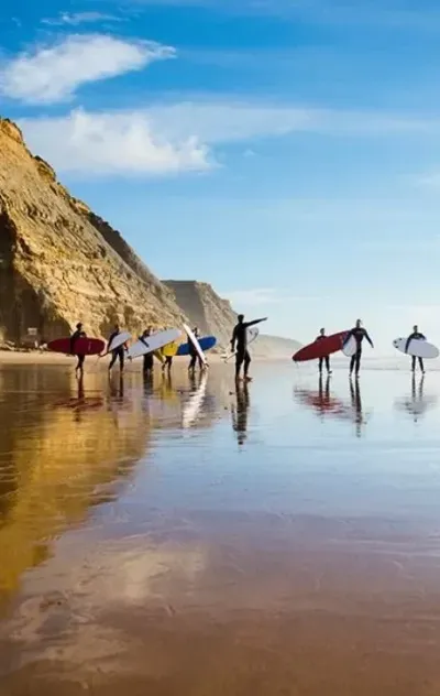 Surfcamp Gruppe am Strand in Ericeira auf dem Weg in die Wellen