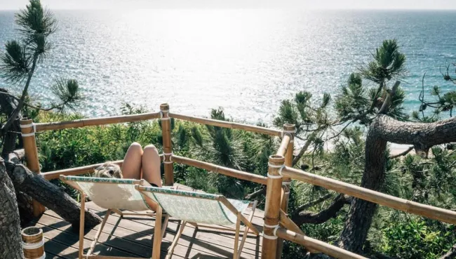 Frau im Liegestuhl mit Blick auf das Meer