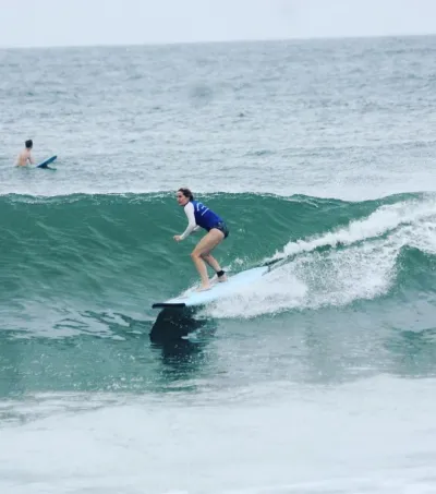 Fortgeschrittene Surferin surft grüne Welle