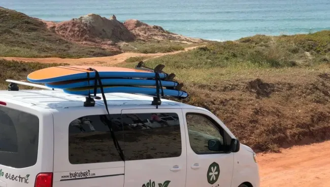 Surfcamp Bulli mit Surfboards auf dem Dach auf dem Weg nach Almagreira zur Surf-Einheit