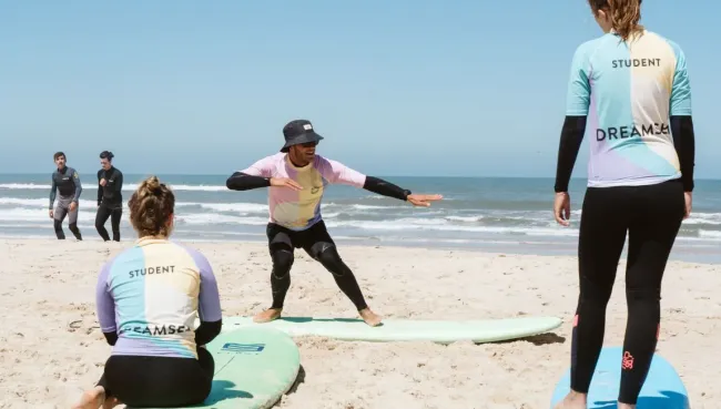 Anfänger:innen lernen in einem Surfcamp in Portugal die Grundlagen des Surfens