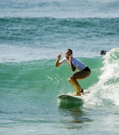 Surf-Anfängerin surft Welle und jubelt