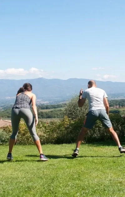 Mann und Frau trainieren mit Blick auf die Landschaft in der Toskana