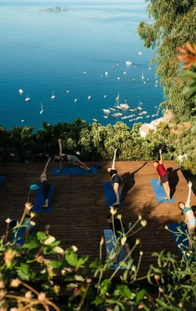 Gruppe bei Yoga Einheit auf Yoga Plattform mit Blick auf das Meer auf Mallorca