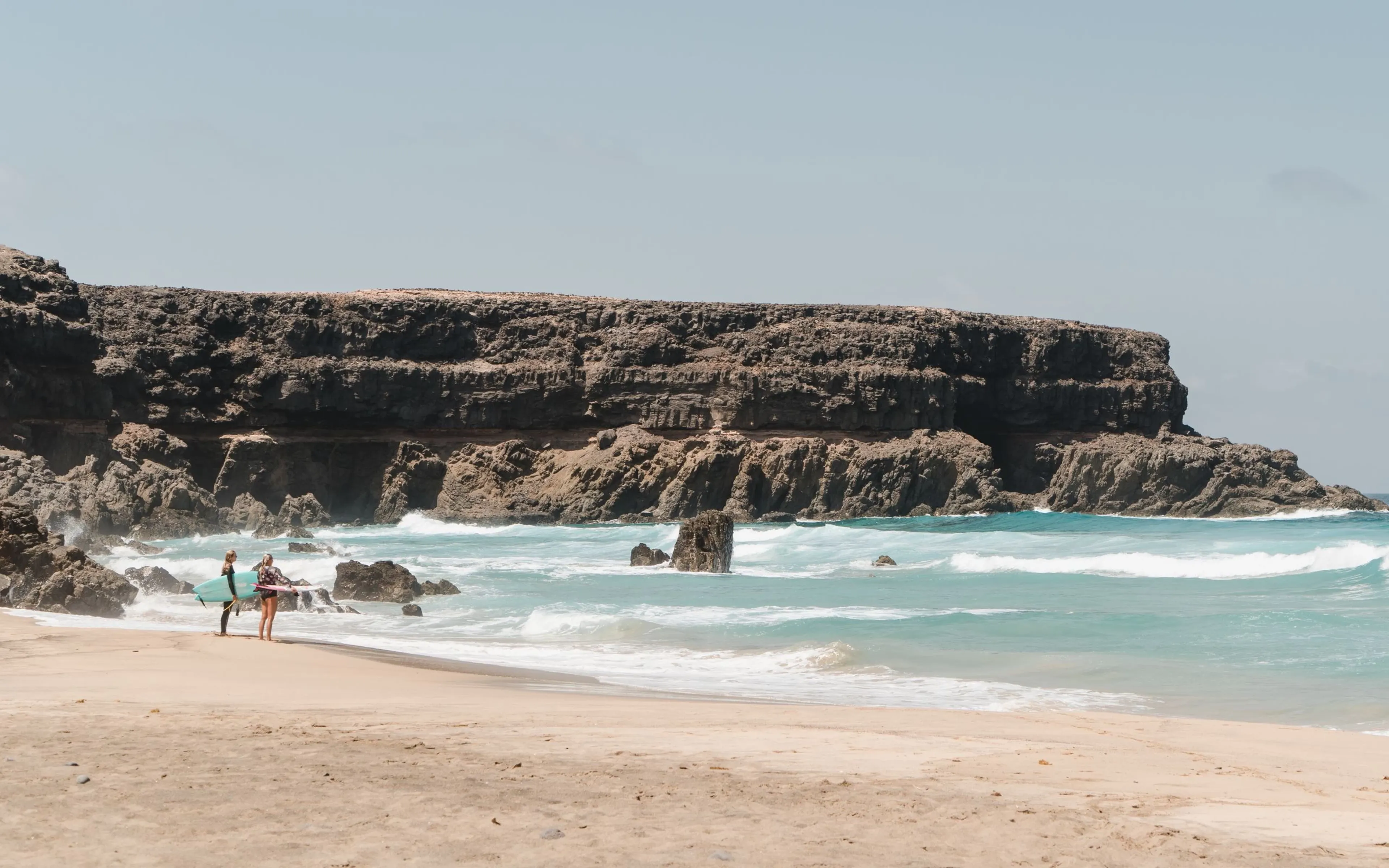 Zwei Surfer mit Surfboards am Strand auf Fuerteventura