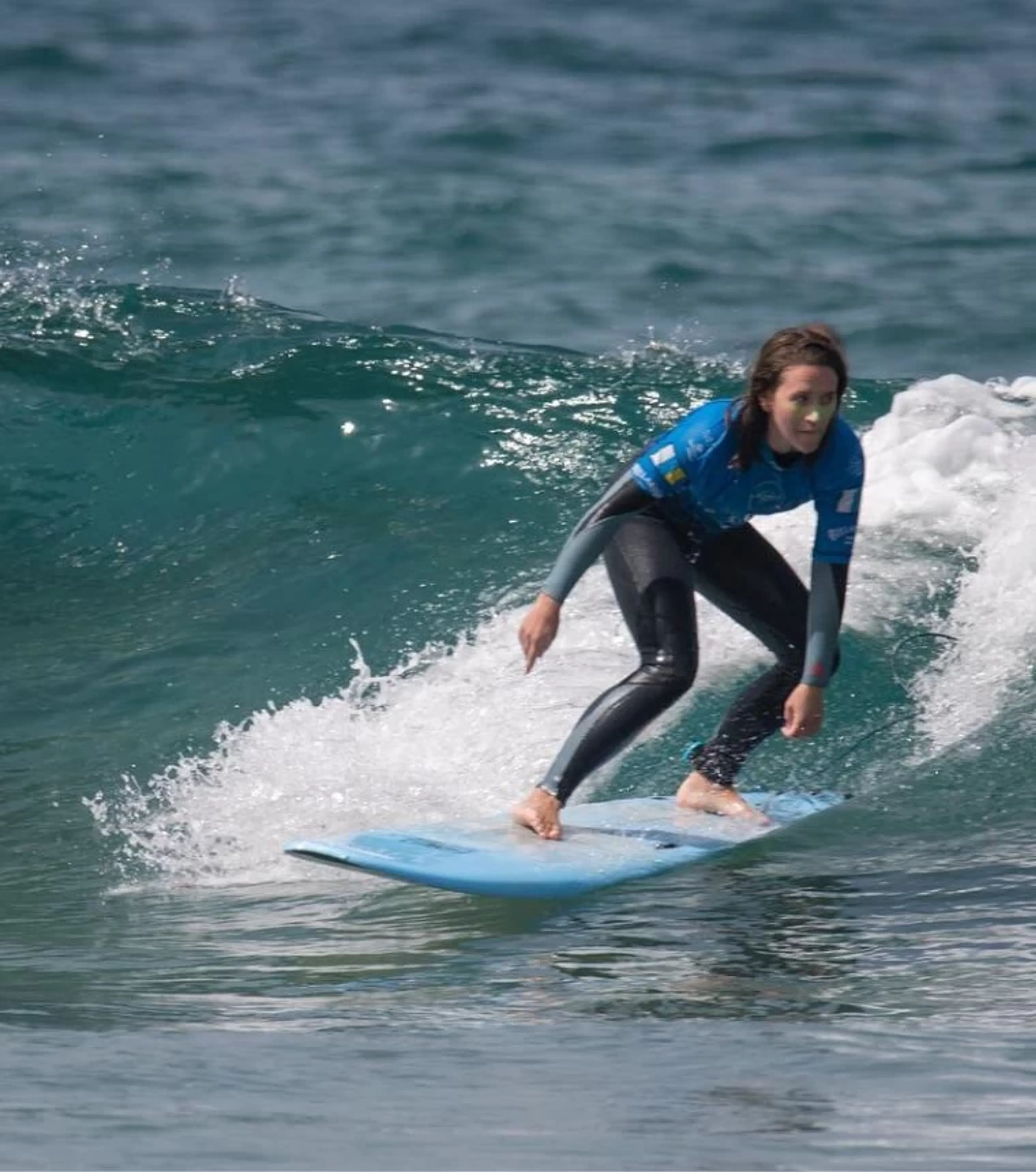 Fortgeschrittene Surfschülerin surft eine grüne Welle auf Gran Canaria