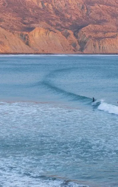 Blick auf Surfer in einer Welle in der Bucht von Imsouane