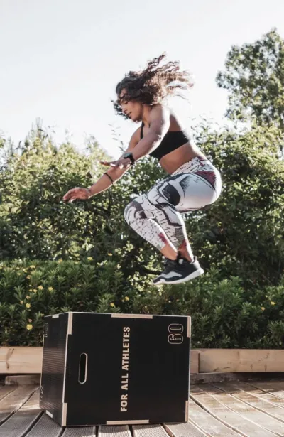 Frau bei Sprungübung beim Fitnesstraining in der Natur