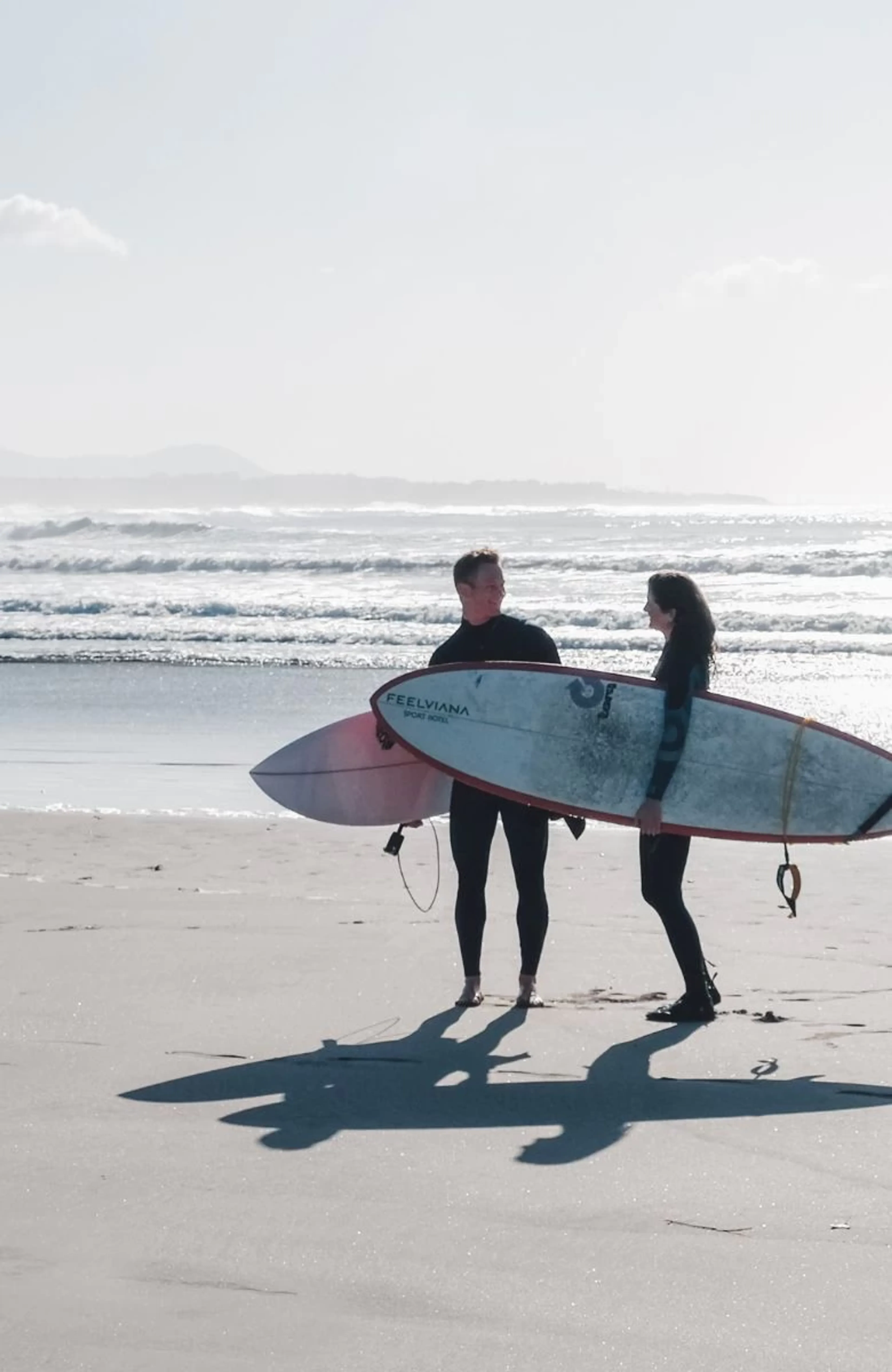 Paar mit Surfboards am Strand in Viana do Castelo im Norden Portugals