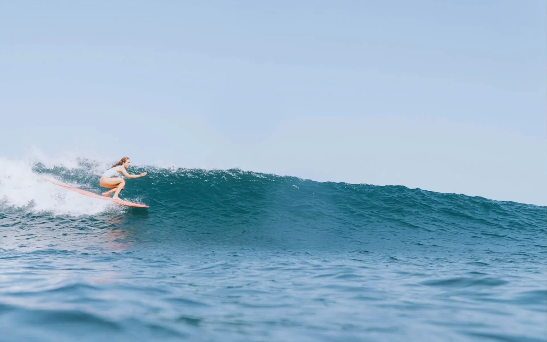 Frau surft Welle auf Longboard in Frankreich