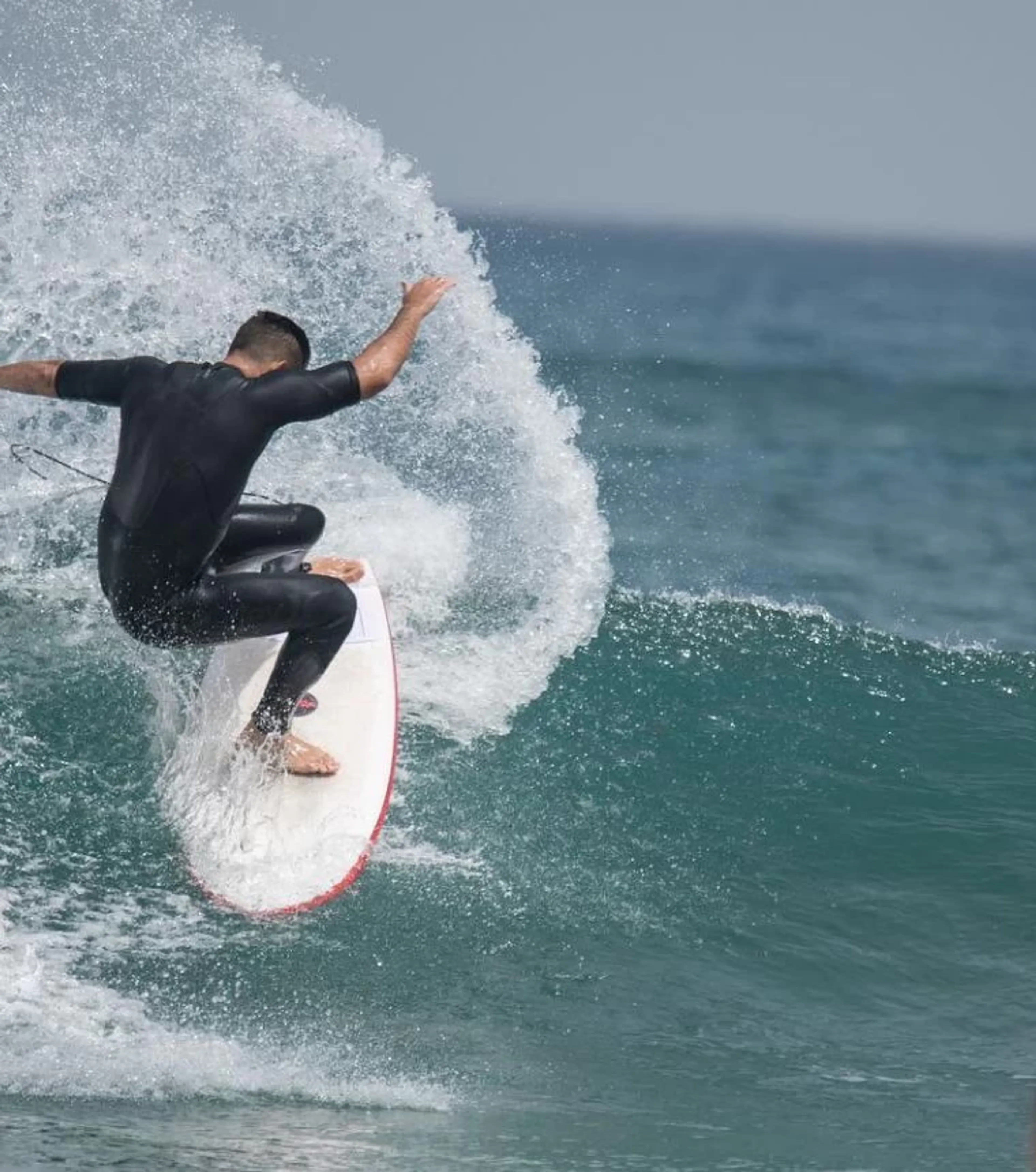Erfahrener Surfer macht einen Turn in einer grünen Welle auf Gran Canaria