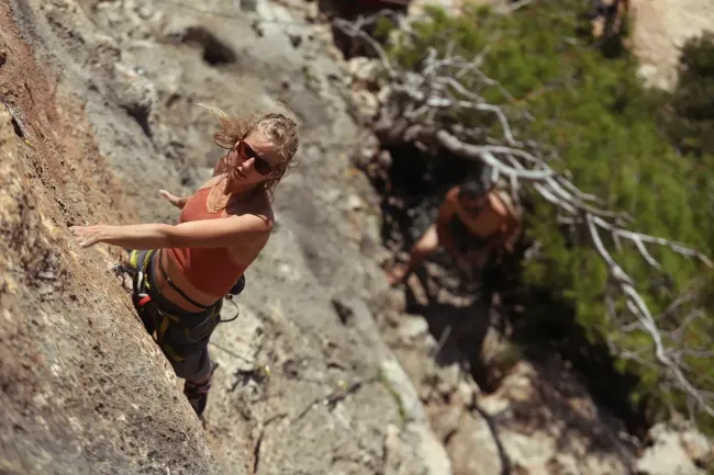 Frau klettert einen Felsen hoch