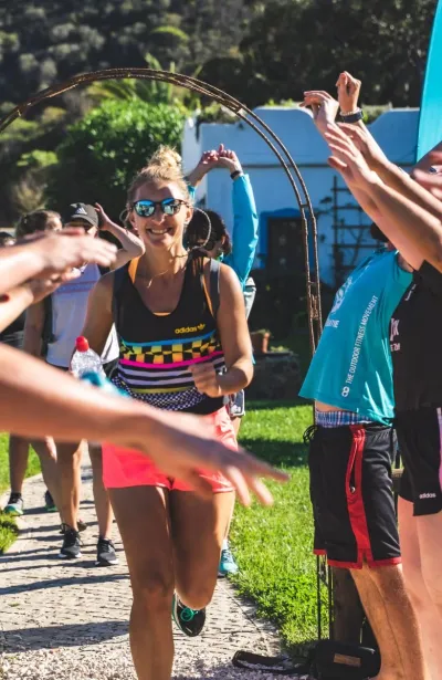 Frau wird beim finalen Einlauf der Yoga und Fitness Reise bejubelt