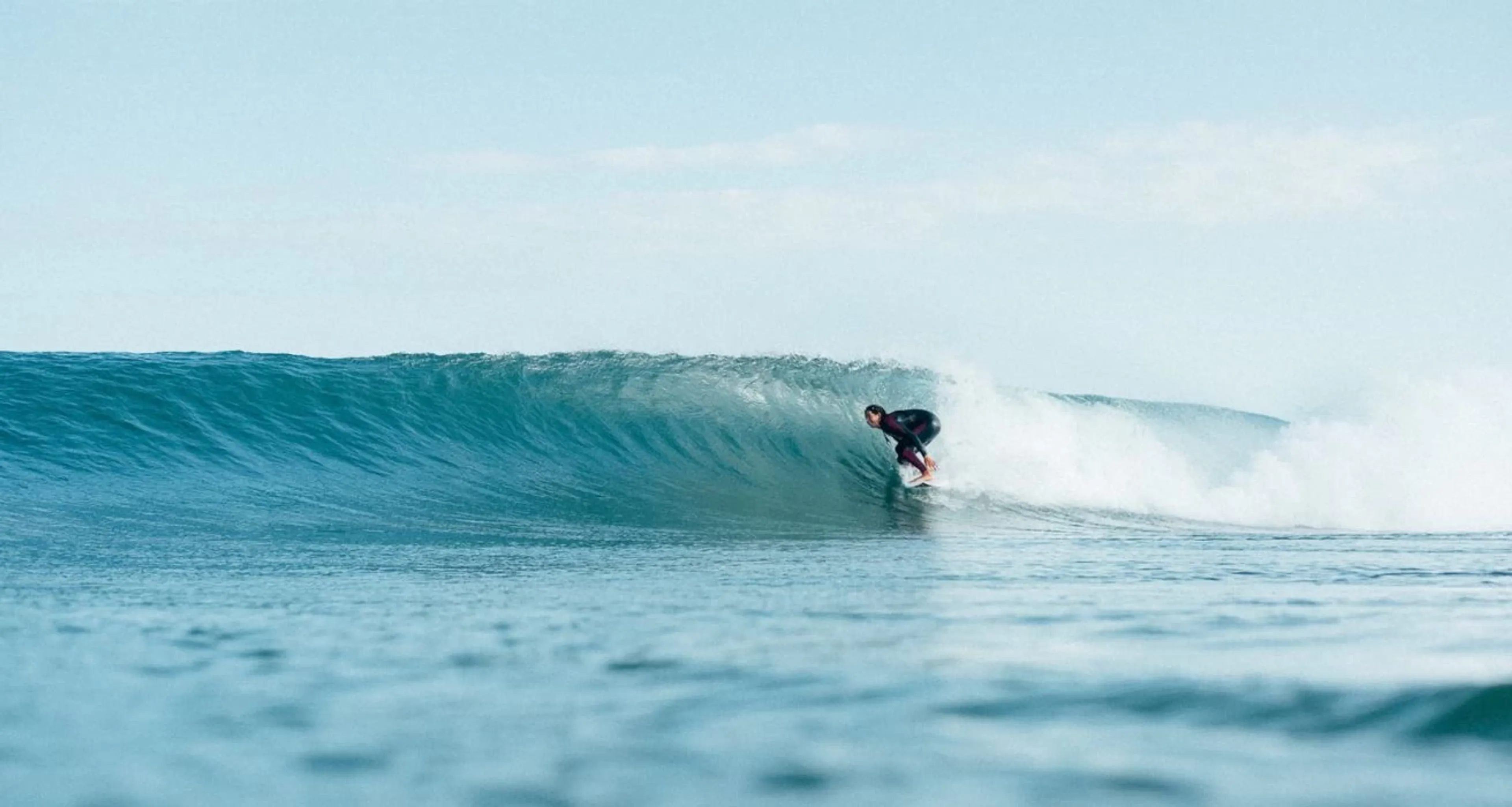 Frau surft perfekte Welle beim Surf-Guiding in Portugal