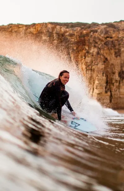 Frau beim Surfen in der Welle in Portugal