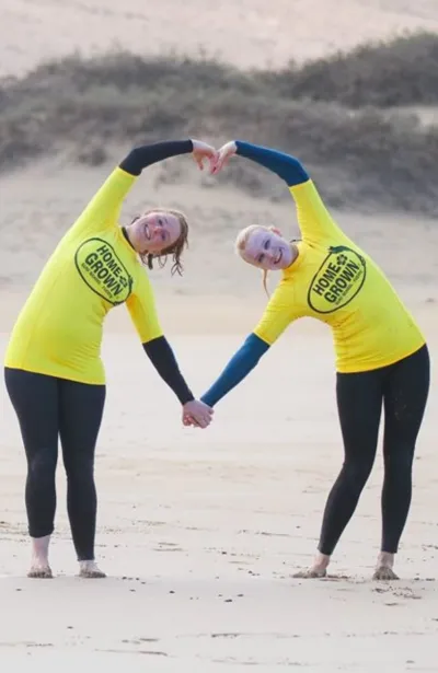 Zwei Freundinnen in Herz-Pose nach der Surf-Einheit am Strand auf Fuerteventura