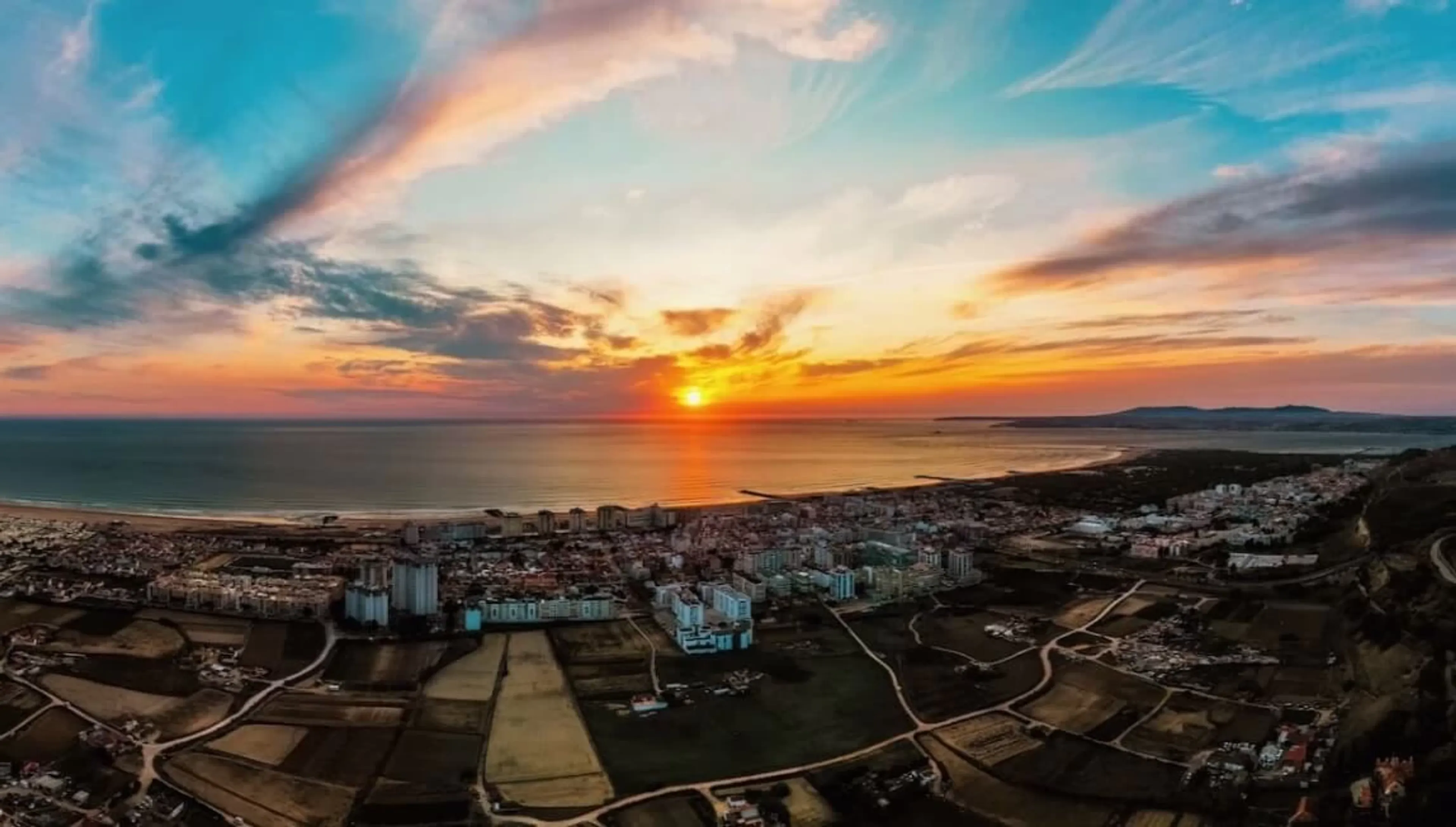 Blick von Lissabon auf die Costa da Caparica und das Meer bei Sonnenuntergang