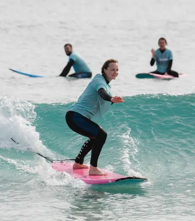Anfängerin surft grüne Welle im Surfcamp auf Fuerteventura