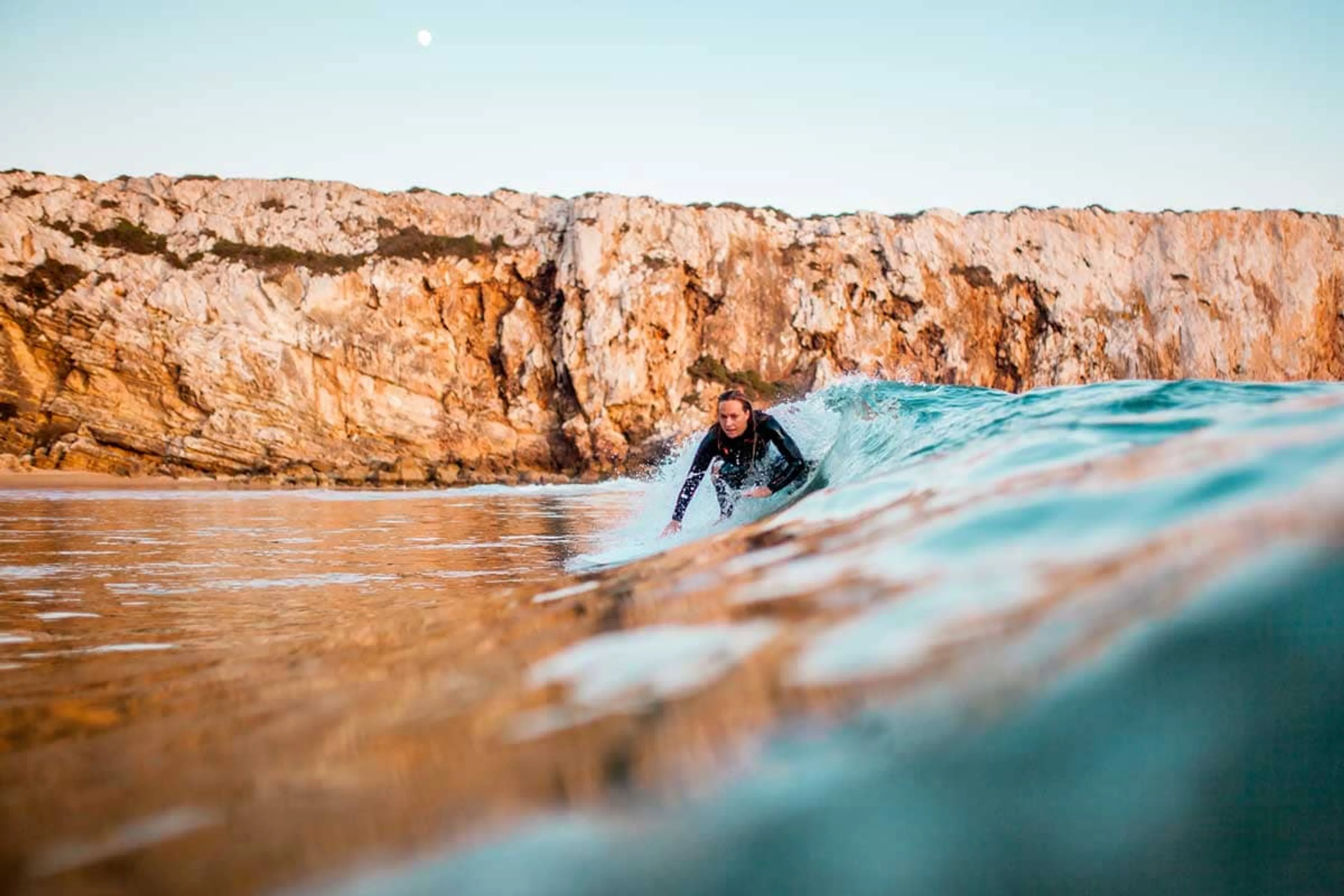 Surferin beim Wellenreiten in einem Surfcamp am Meer